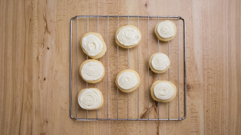 frosted cookies on wire rack on top of wooden surface