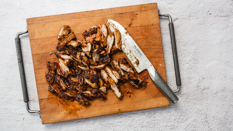 Chipotle honey chicken on cutting board with knife