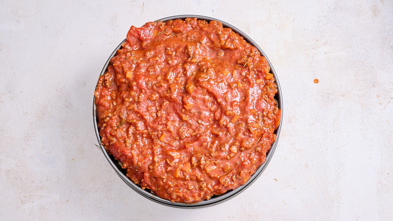 covering pasta with sauce