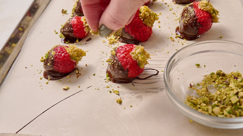sprinkling strawberries with pistachios