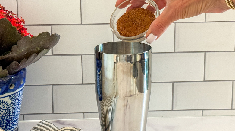 hand adding sugar