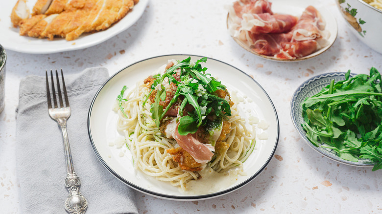 Chicken dish on white plate with components around