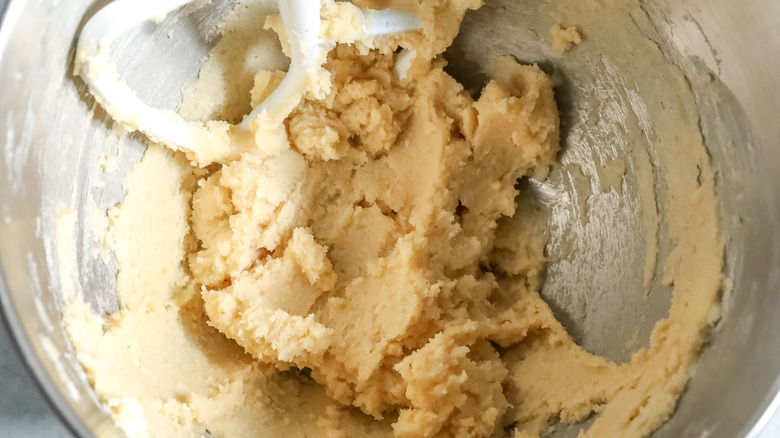 Butter and sugar mixture in stand mixer bowl with paddle attachment