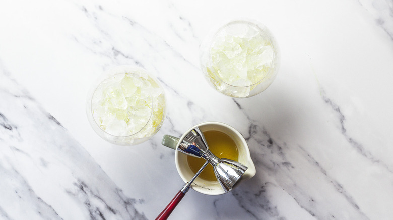 Two spritz glasses with ice and lavender syrup.