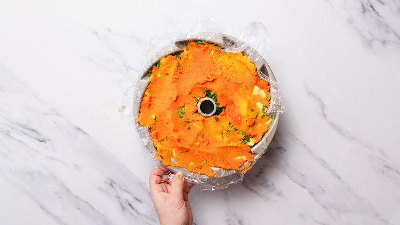 layered sushi bake in plastic wrapped bundt cake