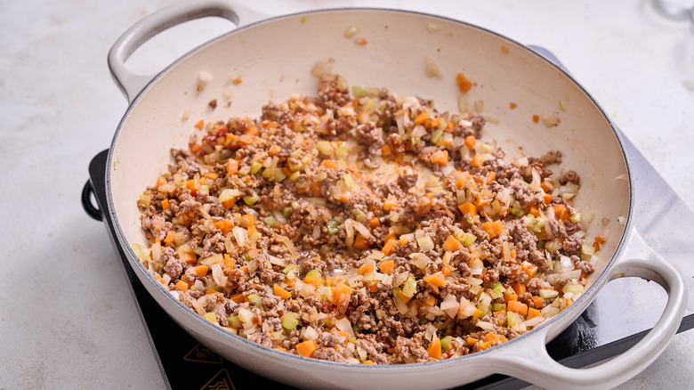 stirring tomato paste into skillet