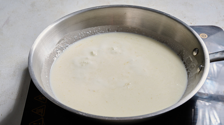 heating the cream in a skillet