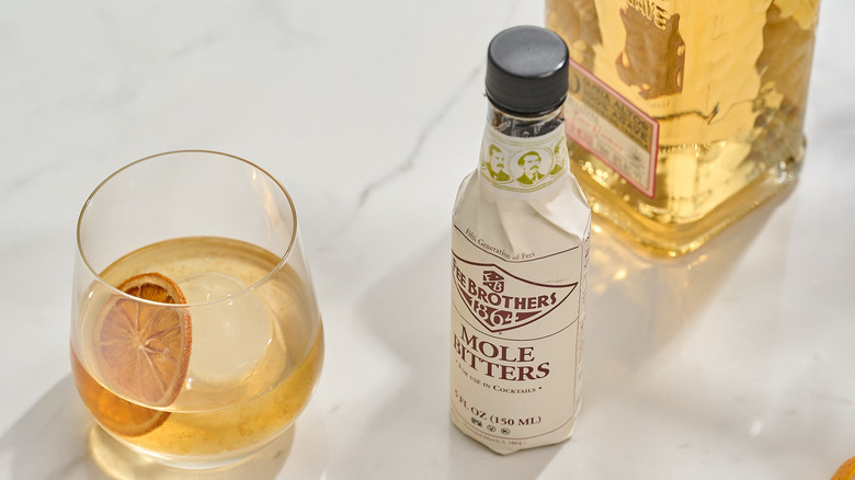 Mole bitters on a table with a cocktail