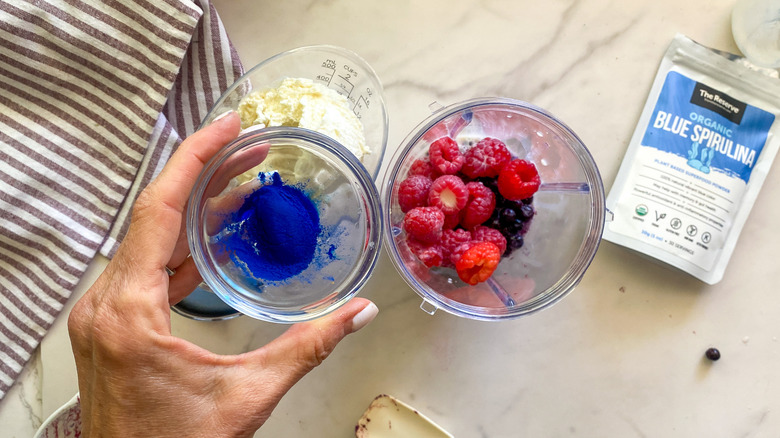 hand holding bowl of blue spirulina
