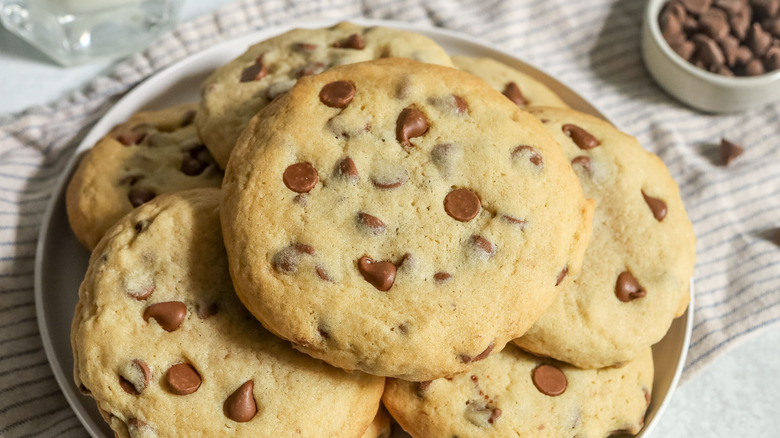Plate of chocolate chip cookies next to small bowl of chocolate chips