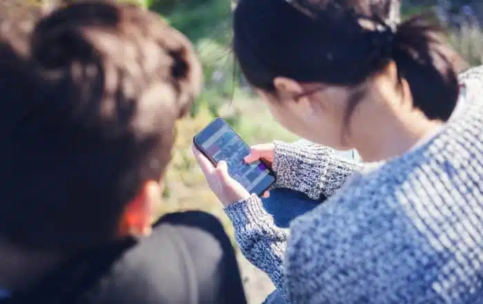 Asian teen boy and girl look in smartphone, communicate, have fun, millenial, teenagers rest together