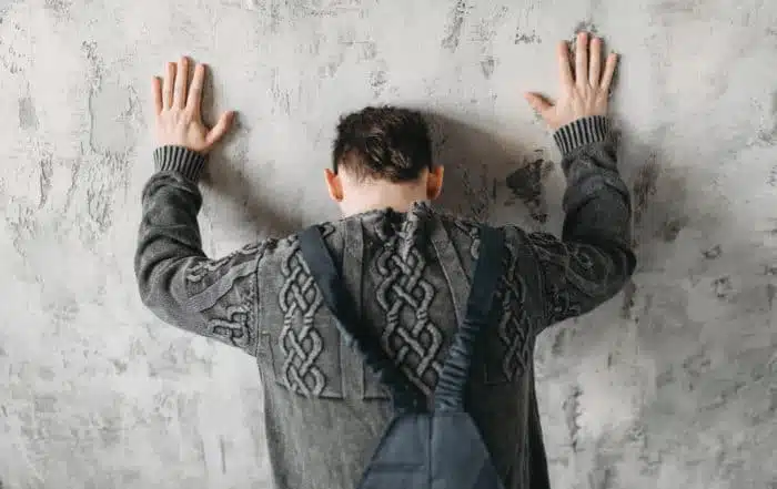 Autistic man stands facing the wall