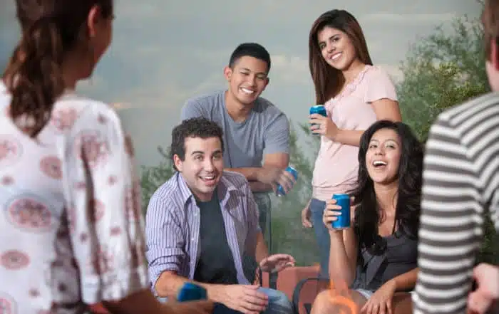 Group of six happy young people socialize outside