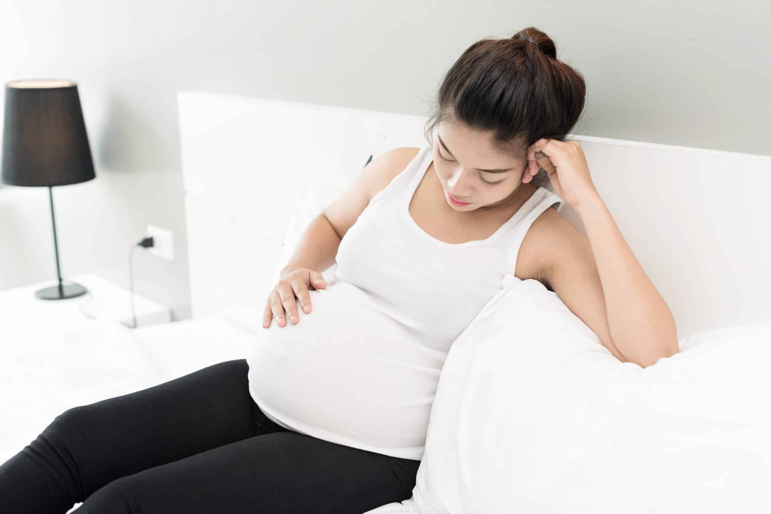 Expecting mother resting on a bed, autism, fever leucovorin and acetaminophen