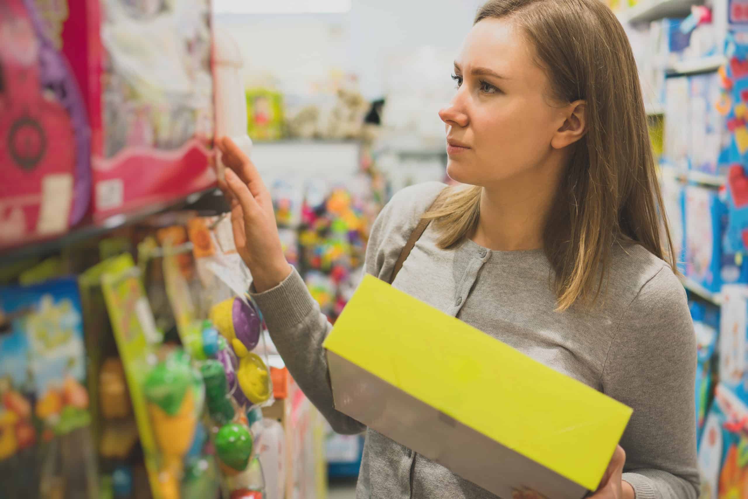 Woman choosing toy in a children's store.