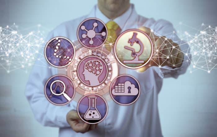 Unrecognizable male scientist is plugging a microscopy app into a brain study interface. Science concept for biosciences, molecular engineering, bioengineering, pharmacogenomics, pharmacogenetics.