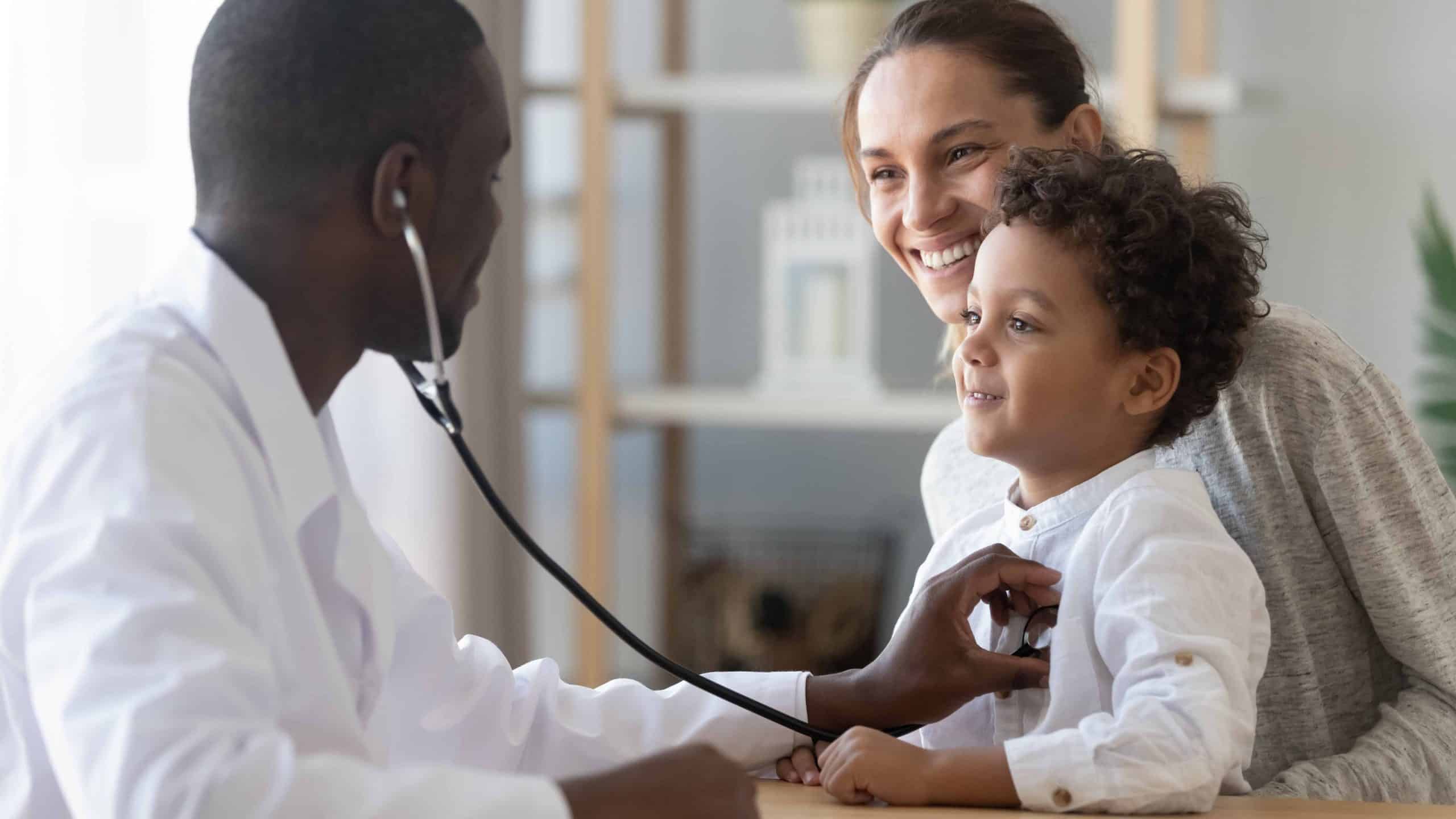 Pediatrician examining a kid while the mother watches