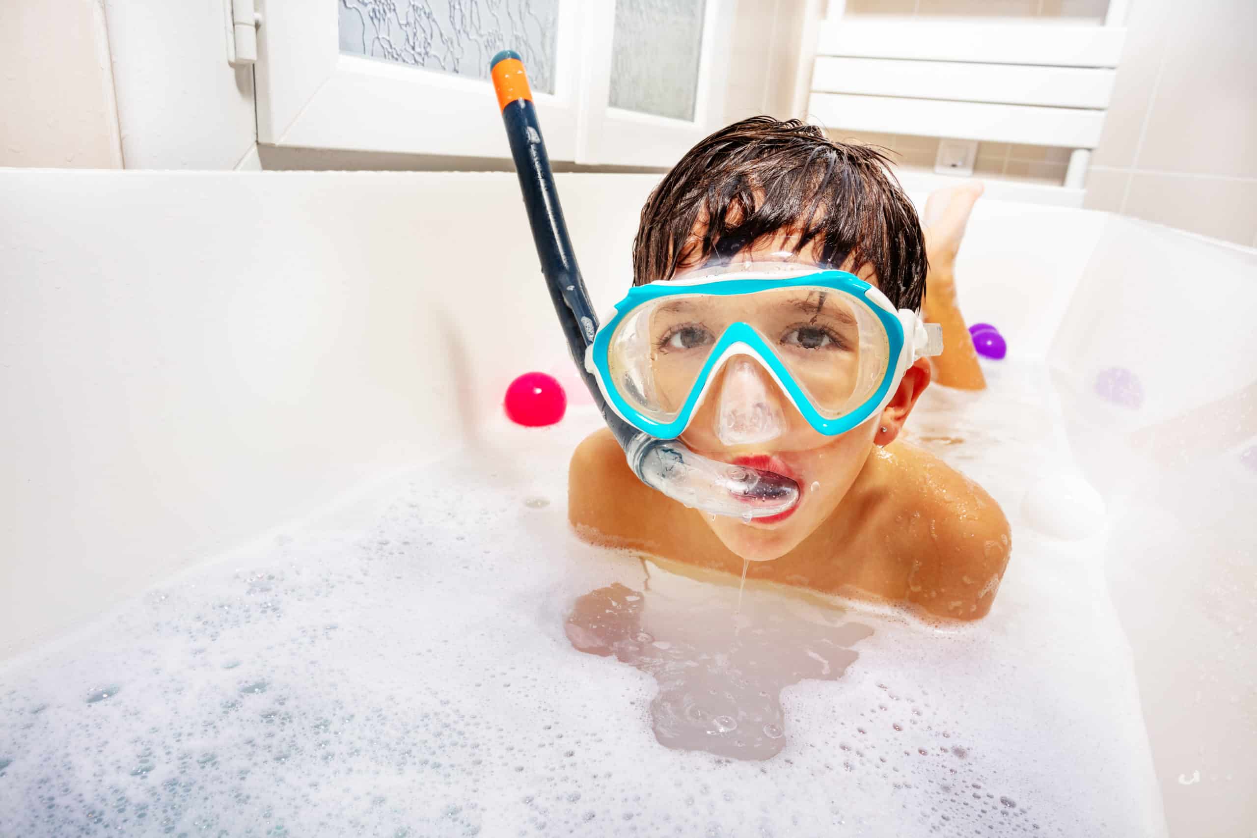 Little cute boy swim and dive in the bathtub wear snorkeling mask, scuba smiling play with soap waiting sea summer vacations