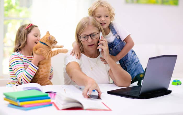 Mother working from home with kids. Quarantine and closed school during coronavirus outbreak. Children make noise and disturb woman at work. Homeschooling and freelance job. Boy and girl playing.