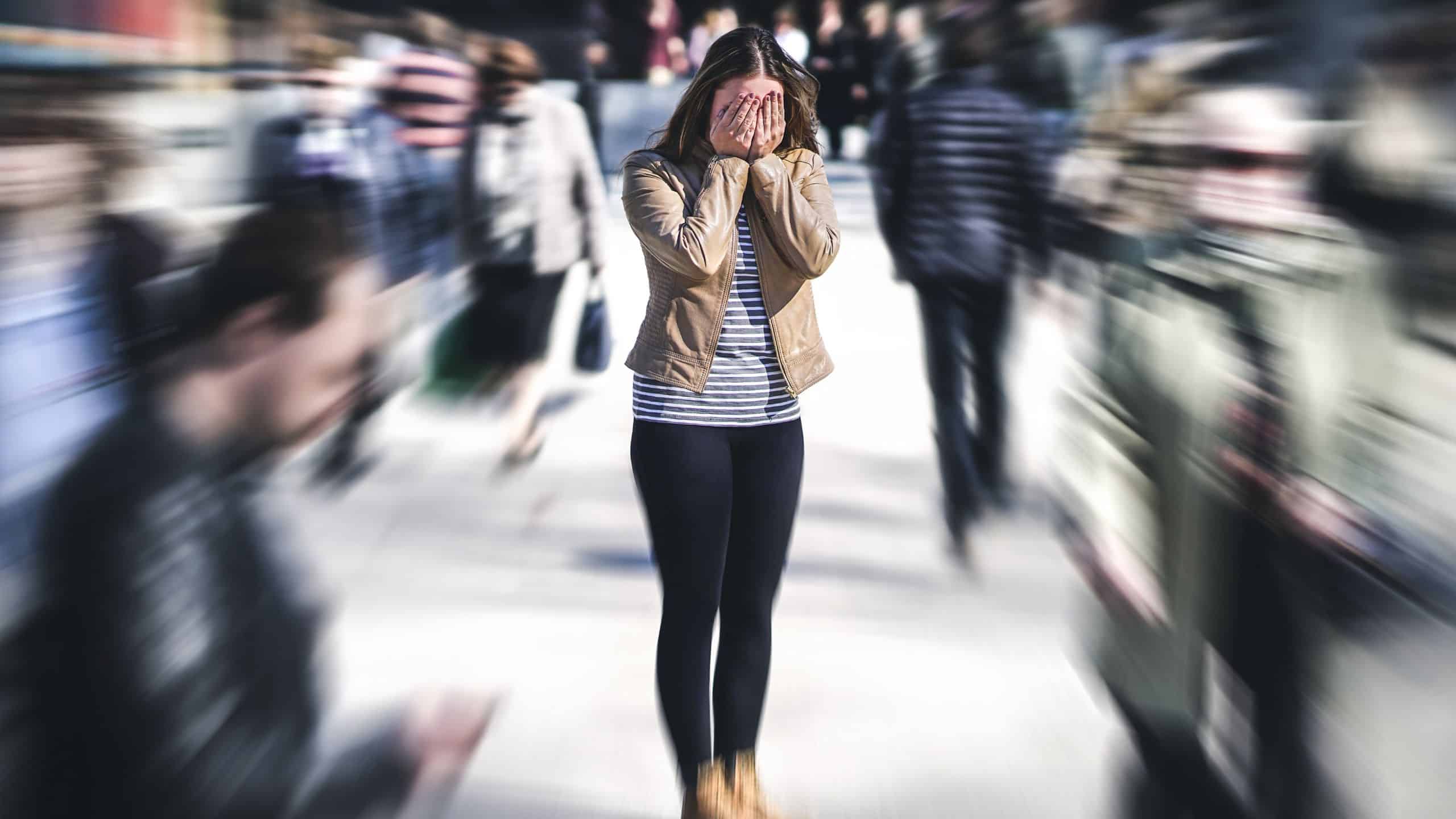 Woman has anxiety in the street and covering her face