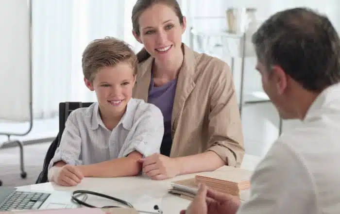 Mature doctor talking to mother and son