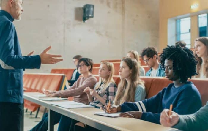 Professor and a group of young students engaged in a classroom discussion
