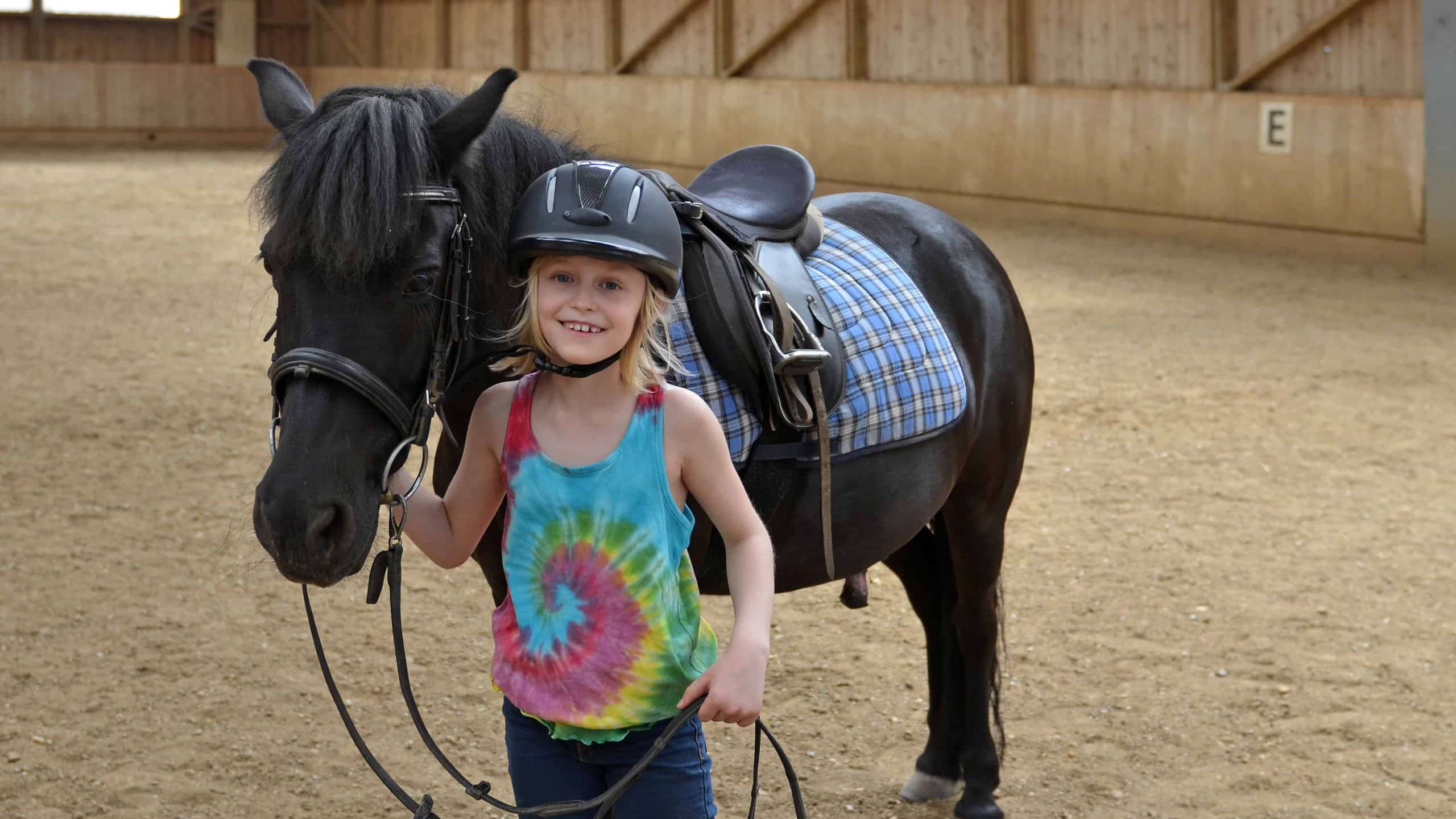 Child standing next to a horse