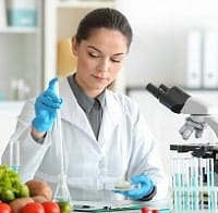 Young female nutritionist testing food samples in laboratory