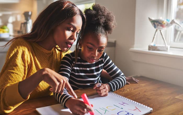 Mom and child studying together, working on homework