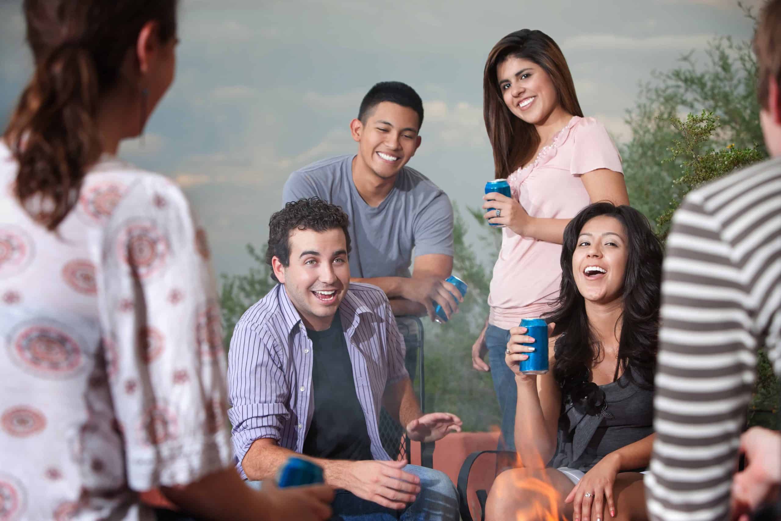 Group of six happy young people socialize outside