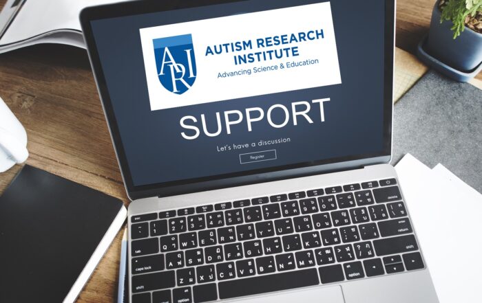 Work desk setup featuring a laptop, coffee cup, notebook, and plant