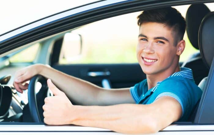 Portrait of Young Man in his Car Showing Thumbs Up