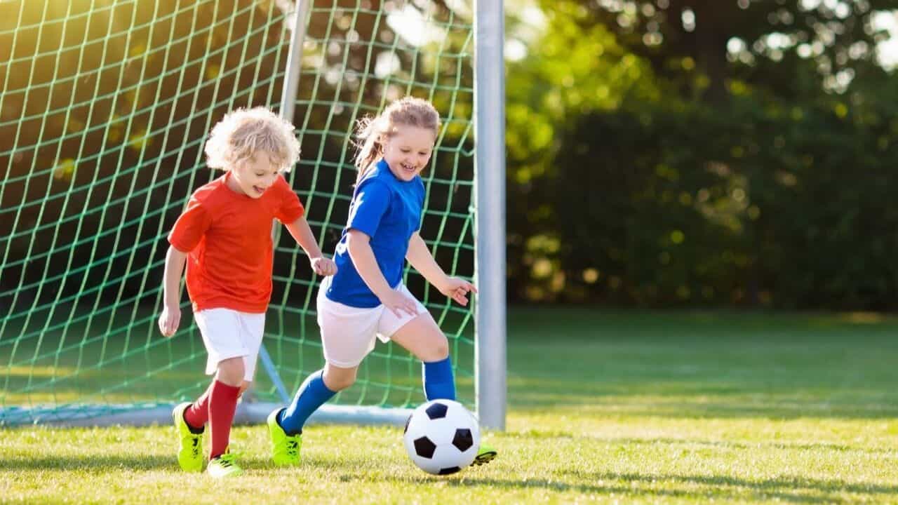 Two young kids having fun playing football
