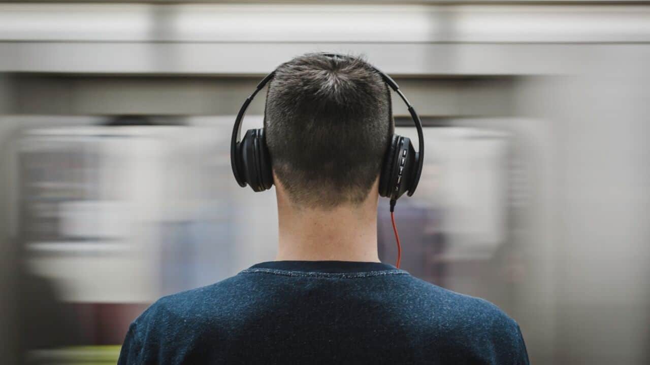 Young man standing with headphones on