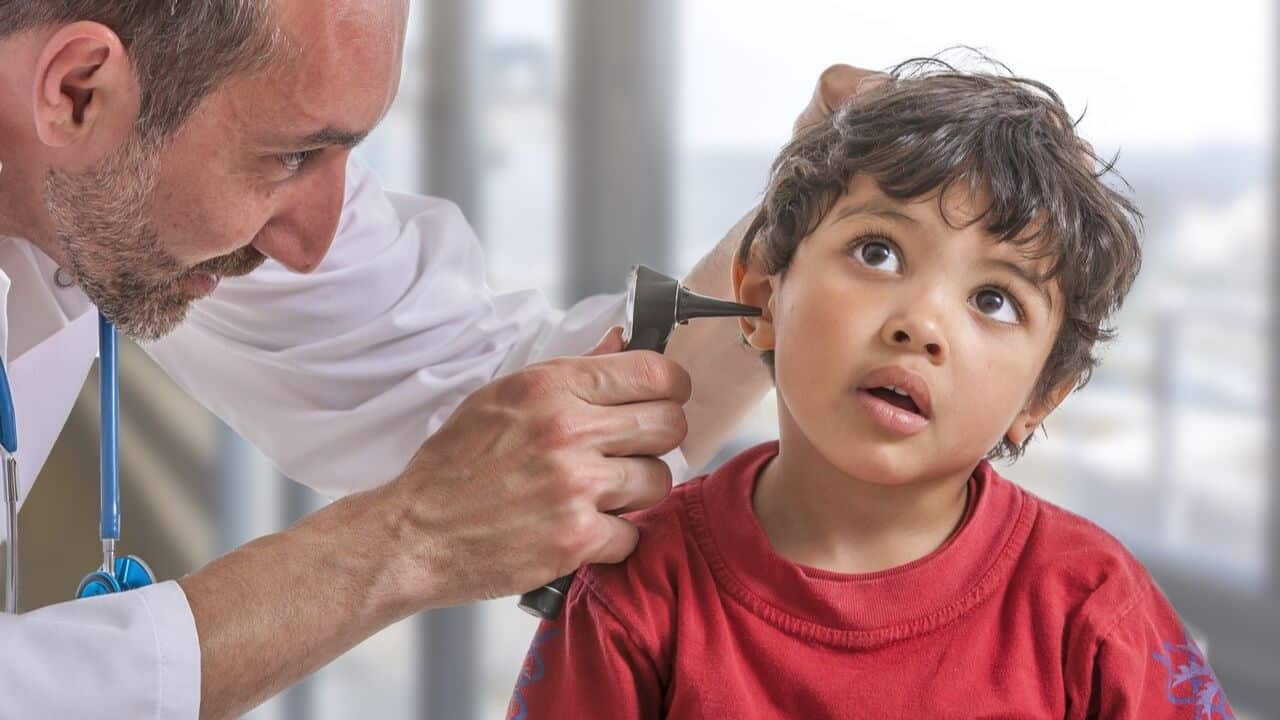 Doctor performing an ear checkup on a child