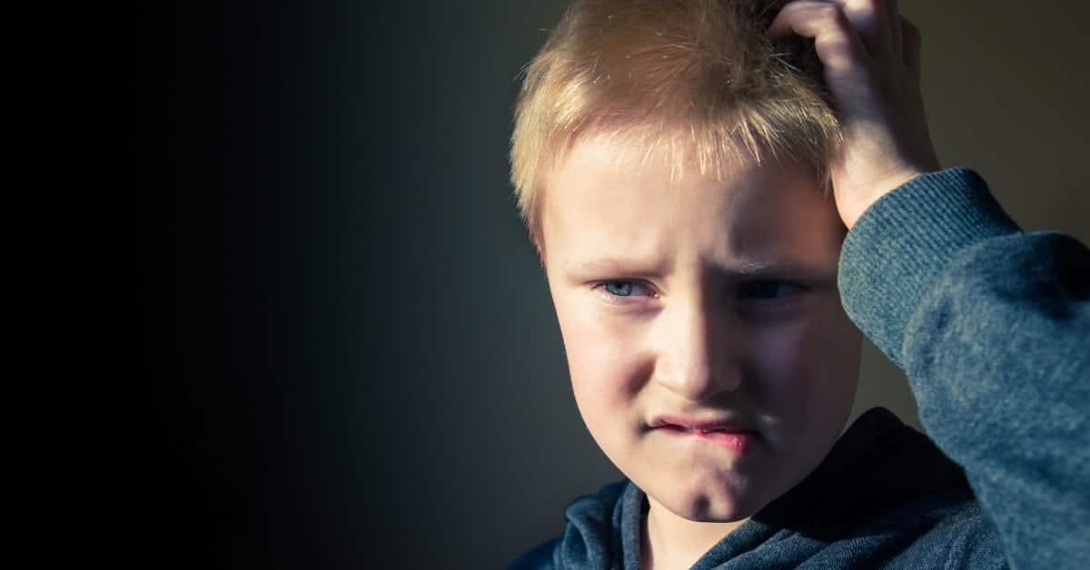 Young kid with a focused expression, biting his lips