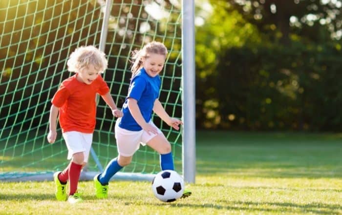 Two young kids having fun playing football