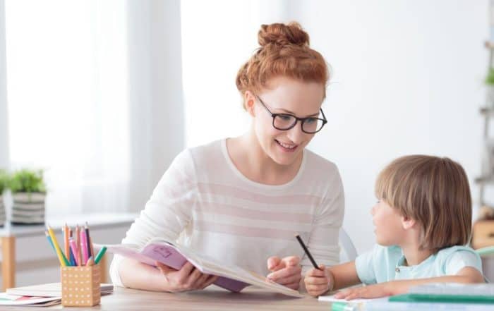 A young child engaging in therapy with a female therapist