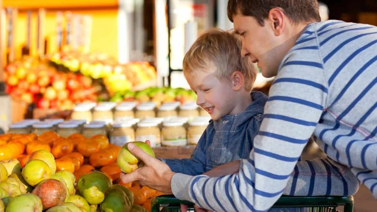 Dad and child selecting fresh fruit at the market