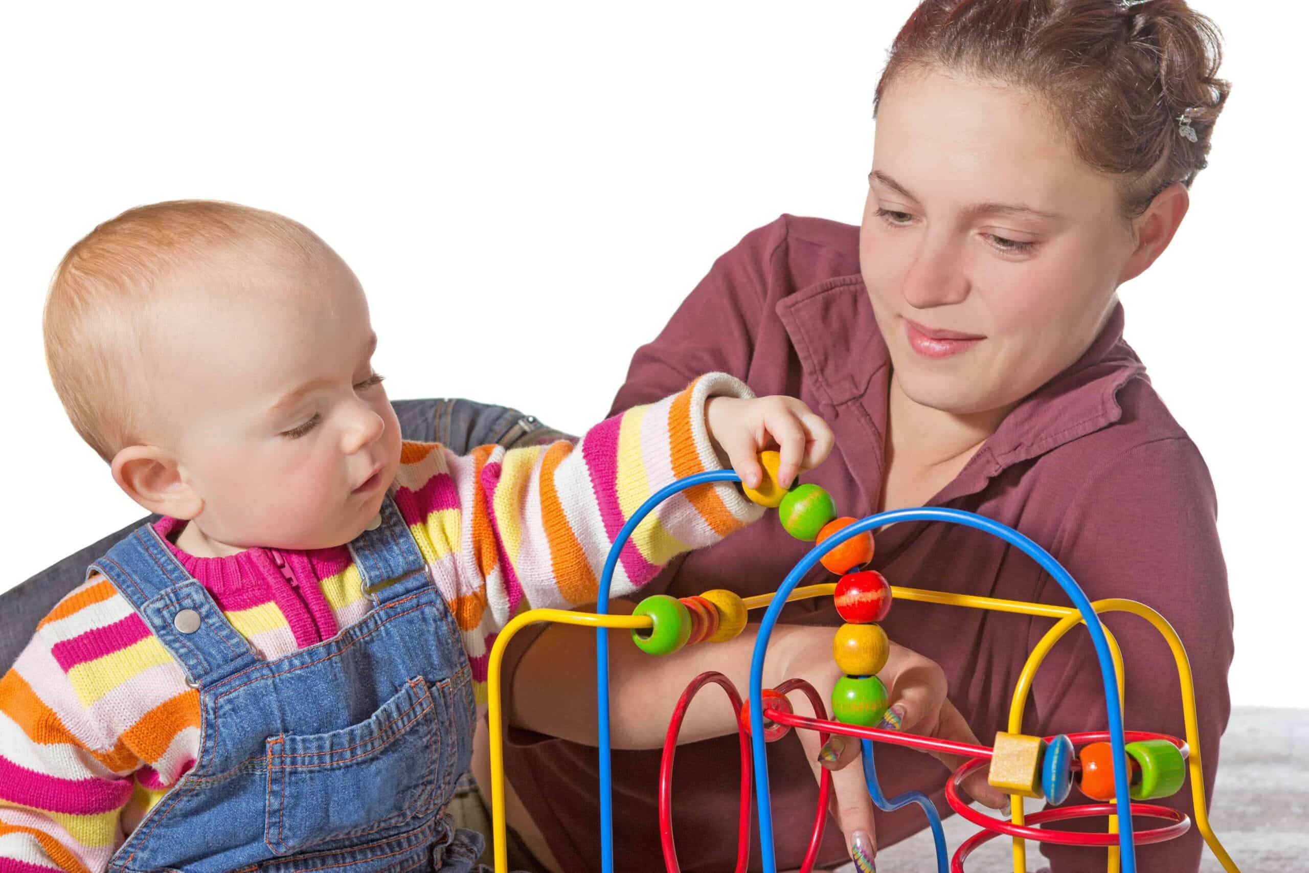 Baby with development delay being stimulated to develop muscle coordination and movement on a bead maze watched by an adult woman