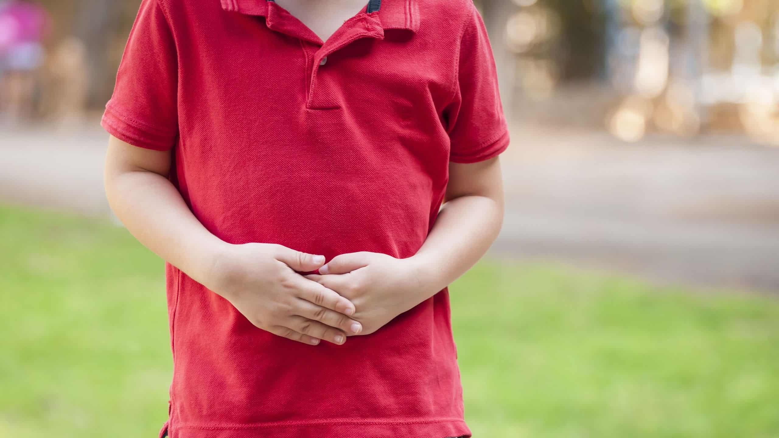 Young child dealing with gut problems, holding their stomach